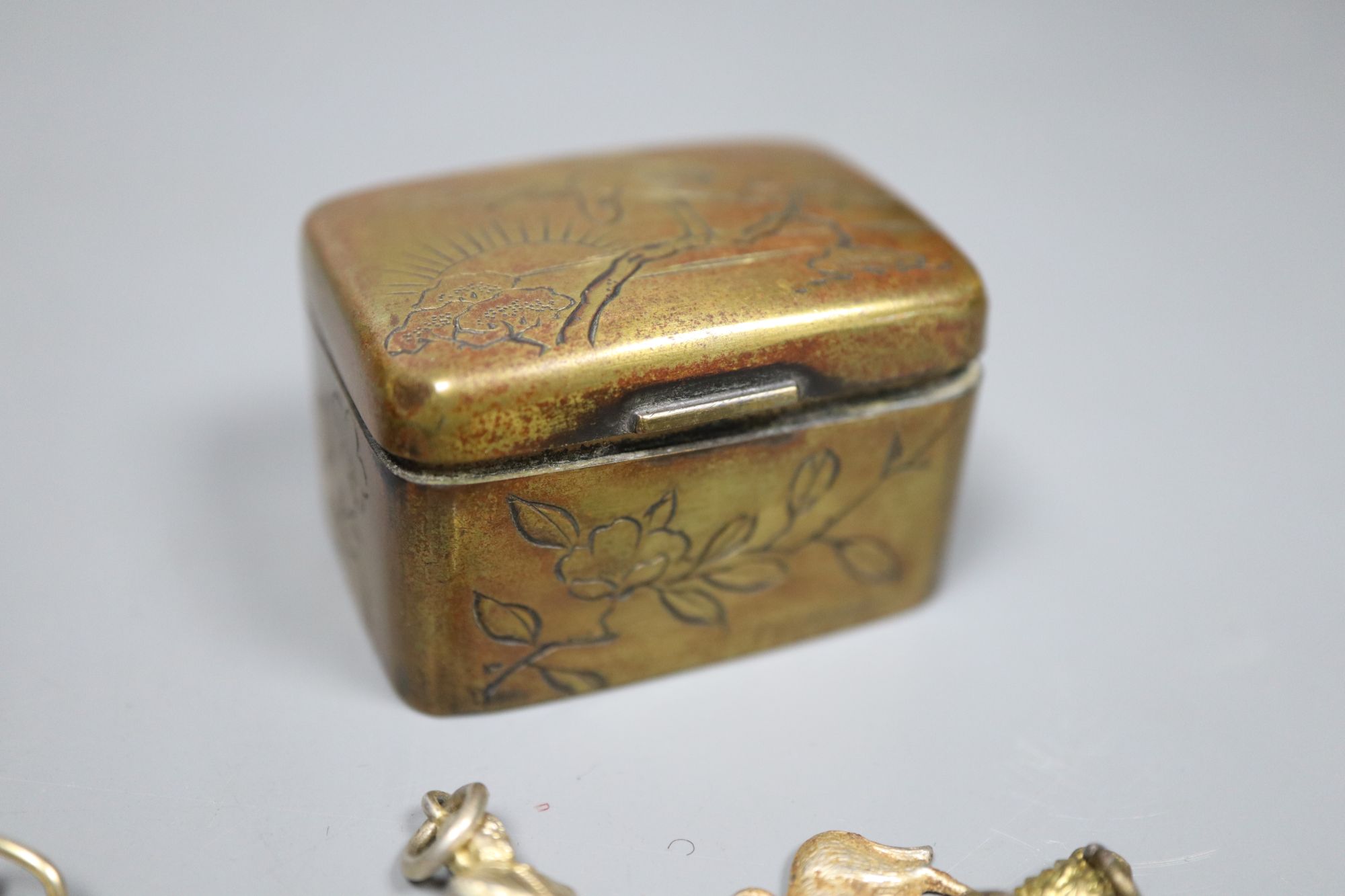 A late Victorian silver mounted tortoiseshell box, (a.f.) one other base metal box and a group of assorted metal charms.